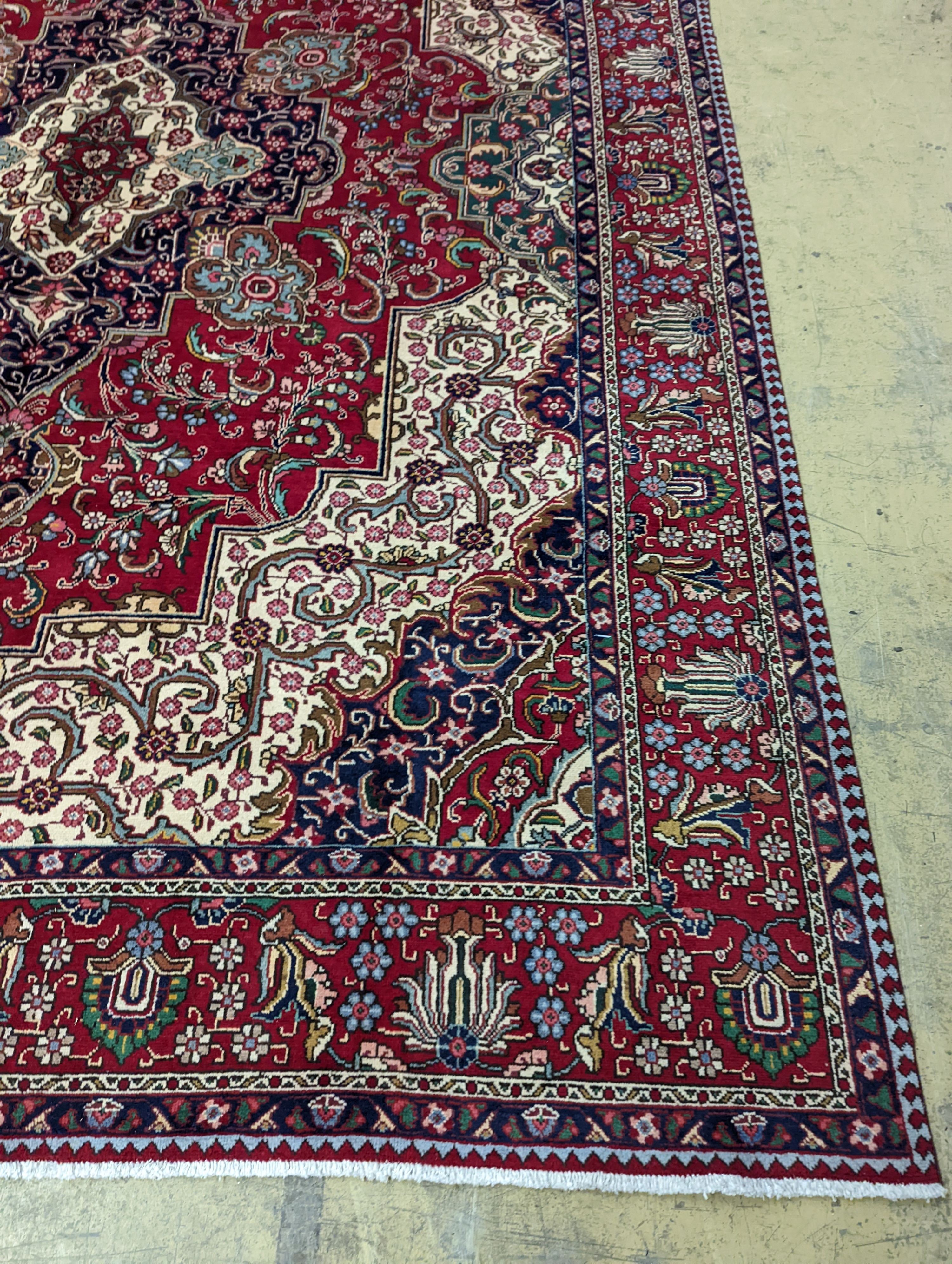 A Tabriz red ground carpet, 405 x 292cm